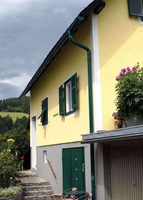Fassade: ADLER Tirosil-Color B02/3 Sommerhaus bzw. Weiß; Festerbalken und Türen: ADLER Pullex Aqua-Color RAL 6005; Dachrinne: ADLER Ferrocolor RAL 6005